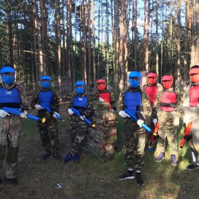 Grupa dzieci w lesie w strojach do paintballu – paintball urodziny dla dziecka.