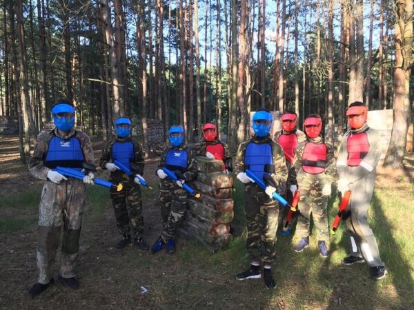 Grupa dzieci w lesie w strojach do paintballu – paintball urodziny dla dziecka.