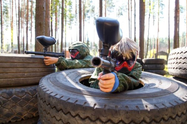Dzieci grające w paintball w lesie, Paintball dla dzieci.